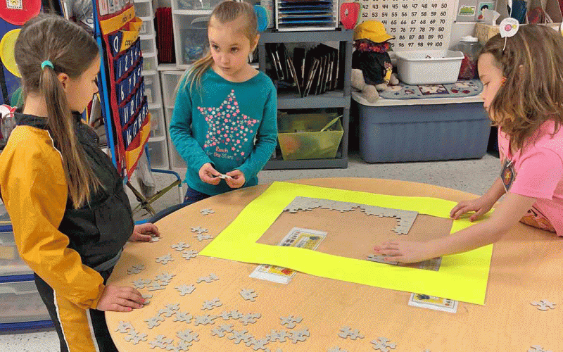 Alyssa, Emileigh, and Ava working on putting together a 100 piece puzzle upside down!