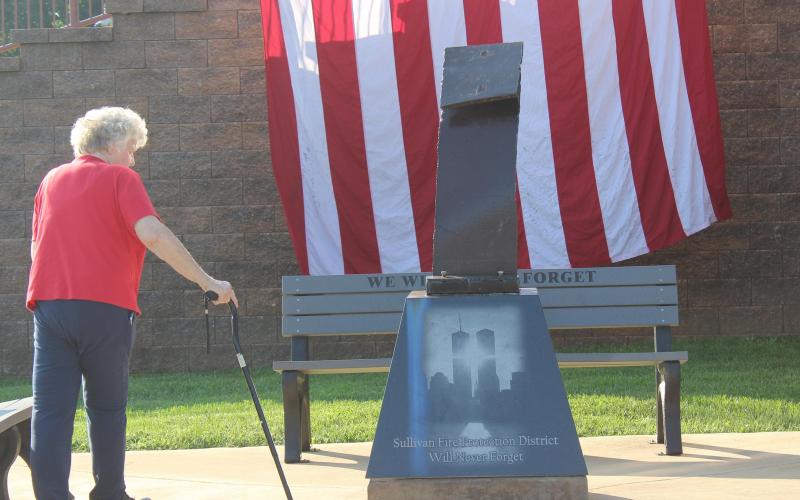 A woman observes the 9/11 Memorial is pictured at Sullivan Station Five in 2019. Article Image Alt Text