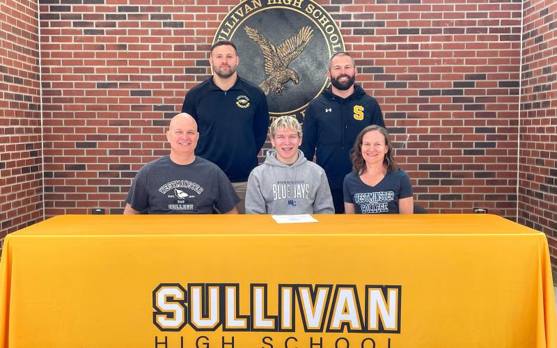 PEREGOY BECOMES A BLUE JAY. Adam Peregoy will take the next step in his wrestling career at Westminster College. In the front row, he is pictured alongside his father, Matt, and his mother, Laura. In the back, he is accompanied by Sullivan High School wrestling coaches Carl Lawrence (left) and Eddie Haar (right). Photo via Sullivan Eagles X Article Image Alt Text