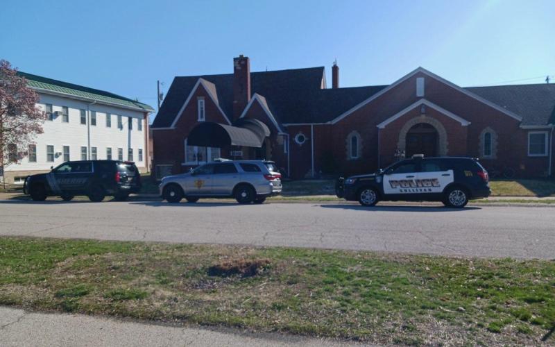 three police vehicles parked in front of a funeral home