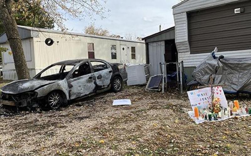 Pictured is the outside of the residence where Justin King was fatally shot Nov. 3, 2021 by his neighbor at the Lakewood Mobille Home Park in Bourbon. Surveillance video showed King and the neighbor spilling out of the entry to the right of the car. The car, belonging to King's shooter, was burned a week later in protest Article Image Alt Text