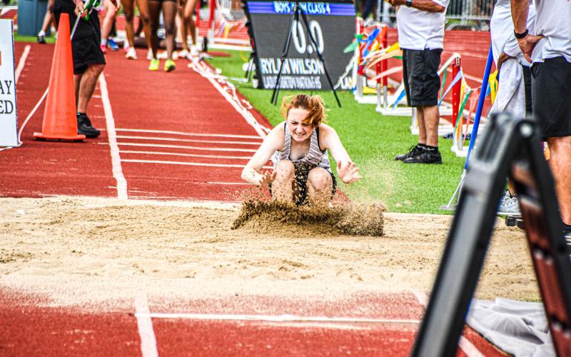 LEAPS AND BOUNDS. Senior Eva Heady made the last landing of her high school career in the triple jump. Photo by Will Johnson Article Image Alt Text