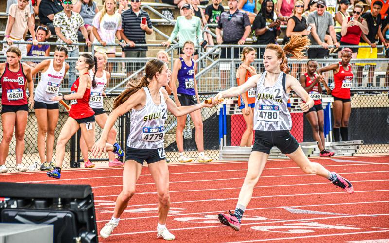 4x400 RELAY. Karlee Head (left) receives baton from Eva Heady (right). Photo by Will Johnson Article Image Alt Text