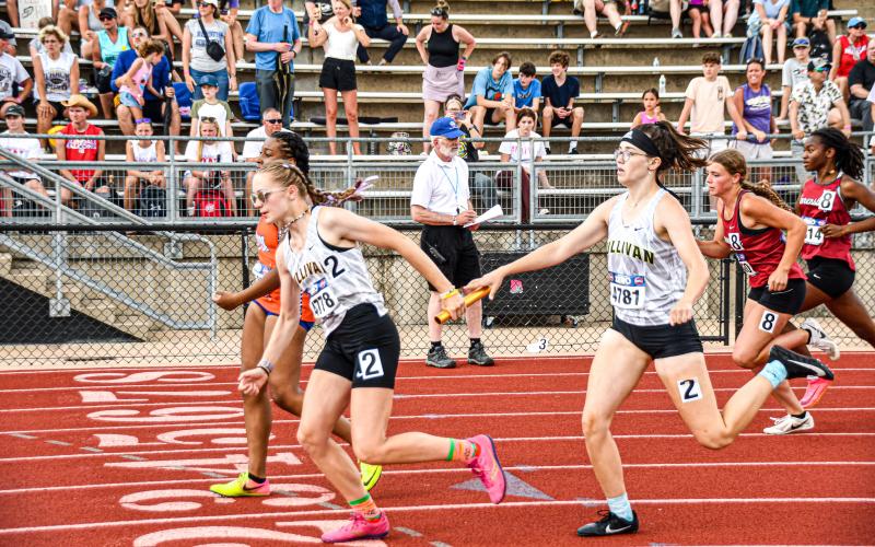 PASSING THE TORCH. Freshman Mariah Denney (left) receives baton from senior Breanna Mayberry (right) during the 4x400-meter relay. Photo my Will Johnson Article Image Alt Text