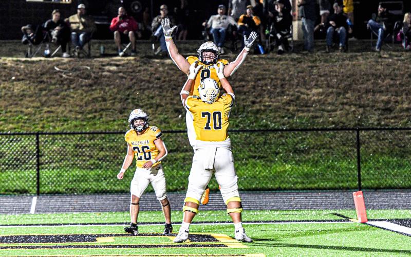 LIFT OFF. Nolan Center (70) celebrates with Chase Blue (8) after he blazed through the end zone. Photo by Extra Innings Photography Article Image Alt Text