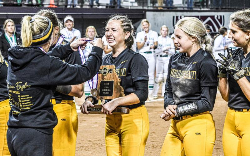 AVA DECLUE (center) is awarded her hard-earned medal after pitching the playoffs. Photo by Extra Innings Photography Article Image Alt Text