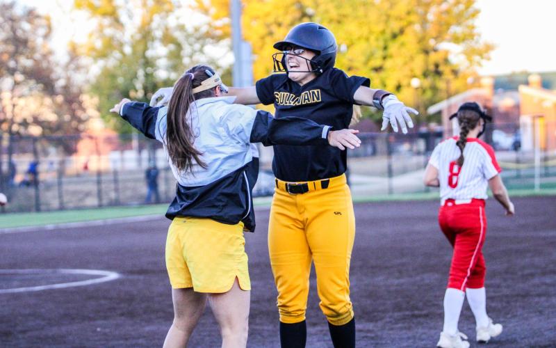 HYPED UP LIKE NO OTHER. Assistant coach Heidi Blankenship (left) congratulates Evelynn Harris (right) with a chest bump after reaching first base. Photo by Wyatt Hardy Article Image Alt Text