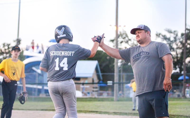 GIMME FIVE. Kameron Schoenhoff (14) high-fived head coach Michael Whalen. Photo by Wyatt Hardy Article Image Alt Text