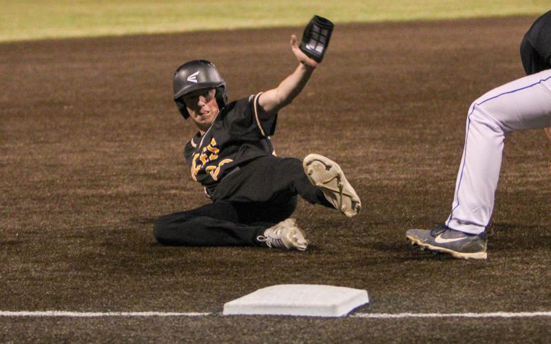 MAHLON FOSTER surfs the dirt into third base. Photo by Wyatt Hardy Article Image Alt Text