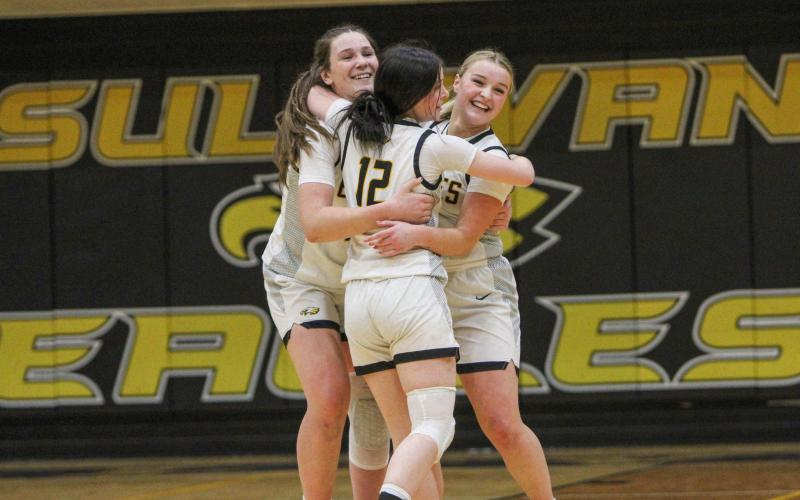 ONE LAST RIDE. Junior Katie Miller (12) is pictured hugging seniors Cora Shetley (left) and Molly Lohden (right) after their last game on their home court. Photo by Wyatt Hardy Article Image Alt Text