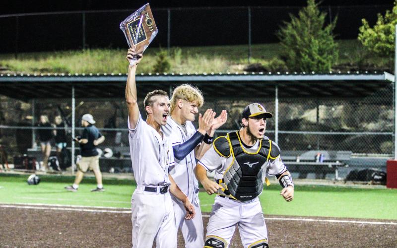 FAREWELL. Seniors Gavin Schmidt (left), Cambrian Koch (center) and Dayton Skaggs (right) celebrate after winning their final district championship as Eagles. Photo by Wyatt Hardy Article Image Alt Text