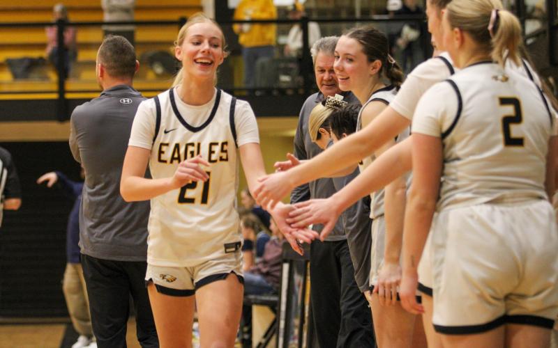 AVA HAYES (21) high-fives her team on the sideline. Photo by Wyatt Hardy Article Image Alt Text