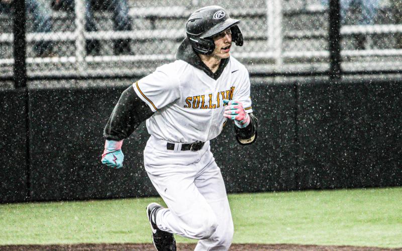 RAIDEN REDD races through the rain to first base. Photo by Wyatt Hardy Article Image Alt Text