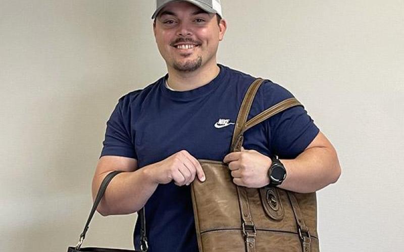 Dalton Nilges is pictured showing off purses Article Image Alt Text