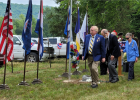 Sons of the American Revolution placing flowers by the grave marker.